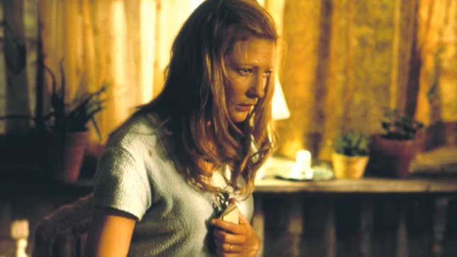 A character holds an object to her chest.