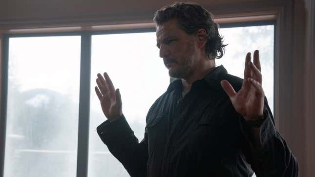 Joel raises his hands and looks at something off-screen.